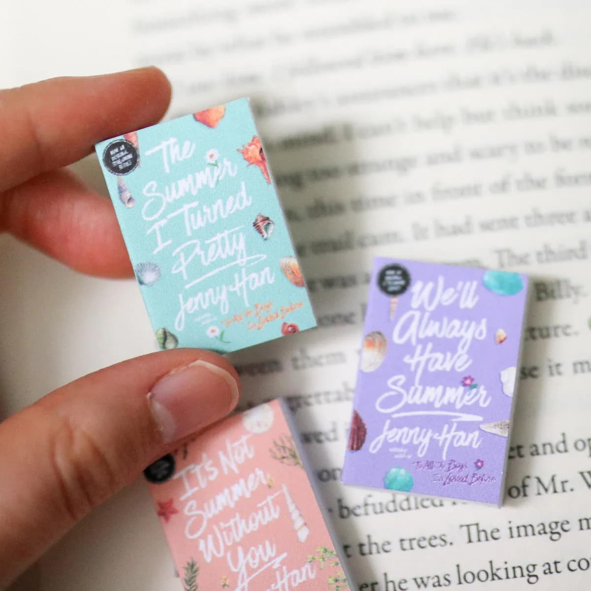 Pastel mini covers from both trilogies spread across an open book